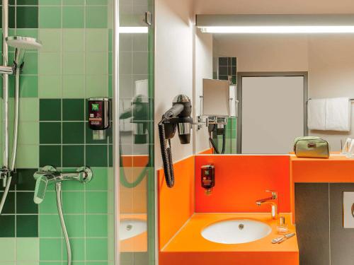 a bathroom with a shower with a sink and a phone at ibis Styles Speyer in Speyer