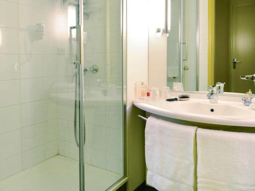 a bathroom with a glass shower and a sink at ibis styles Dax Centre in Dax