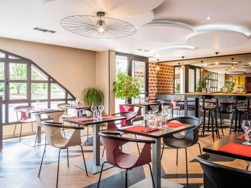 a restaurant with tables and chairs and a bar at Ibis Styles Reims Centre in Reims