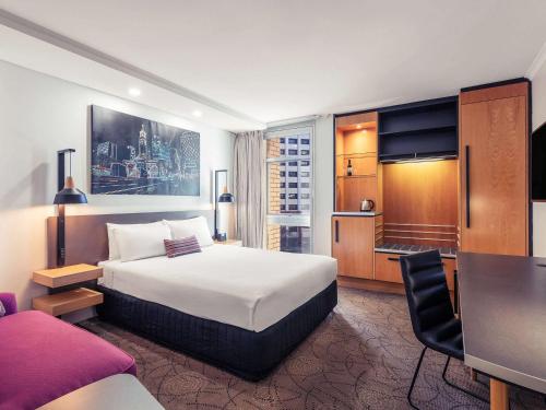 una camera d'albergo con letto e scrivania di Mercure Brisbane King George Square a Brisbane