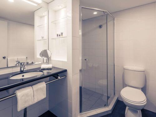 La salle de bains est pourvue de toilettes, d'un lavabo et d'une douche. dans l'établissement Mercure Brisbane King George Square, à Brisbane