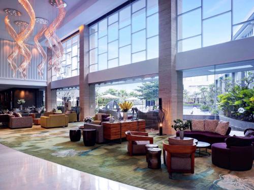 a lobby with couches and chairs in a building at Grand Mercure Bandung Setiabudi in Bandung