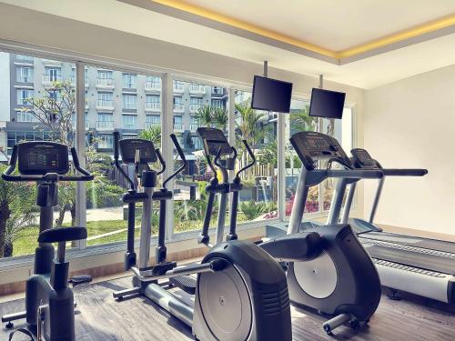 a row of exercise bikes in a gym with a window at Grand Mercure Bandung Setiabudi in Bandung