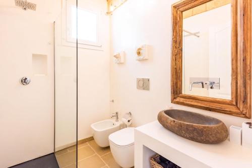 a bathroom with a sink and a toilet and a mirror at Leukos, dimora di charme in Salve