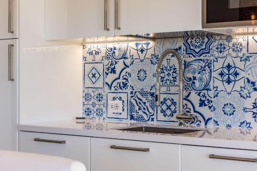 薩維的住宿－Leukos, dimora di charme，厨房的墙壁上铺有蓝色和白色的瓷砖。