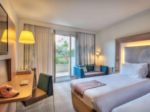 a hotel room with a large bed and a desk at Novotel Marseille Centre Prado Vélodrome in Marseille