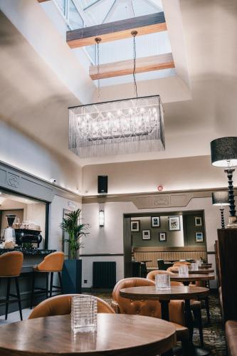 a restaurant with tables and chairs and a chandelier at The Station Hotel in Aberdeen