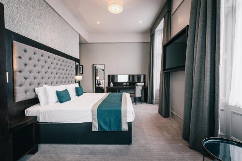 een hotelkamer met een bed en een bureau bij The Station Hotel in Aberdeen