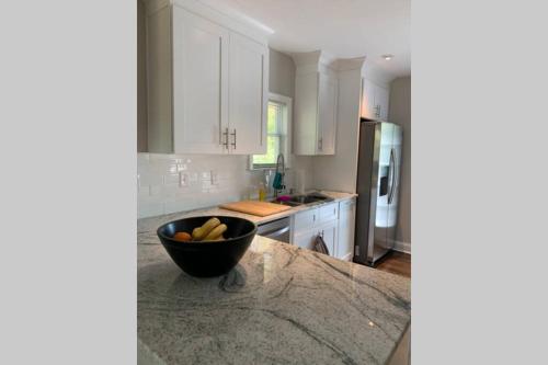 a kitchen with a bowl of fruit on a counter at Modern Home:3 Bedroom;2.5 Bath Near M-Benz Stadium in Atlanta