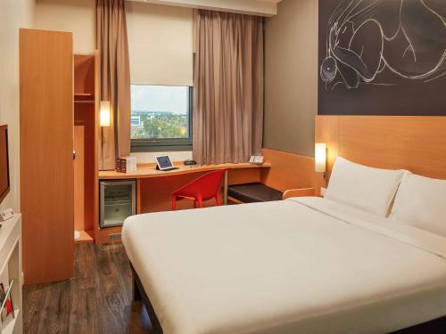 a hotel room with a large bed and a desk at ibis Ankara Airport Hotel in Ankara