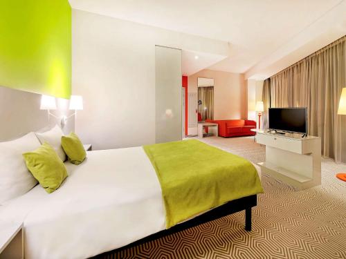 a hotel room with a large bed and a television at Ibis Styles Wroclaw Centrum in Wrocław