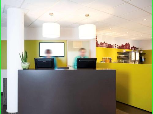 an office with two people sitting at a desk at ibis Styles Hotel Brussels Centre Stéphanie in Brussels