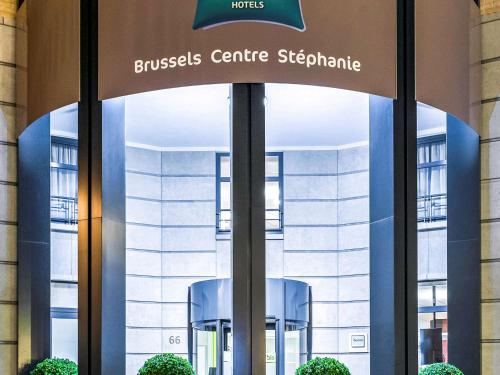 a sign in front of a building with a chair at ibis Styles Hotel Brussels Centre Stéphanie in Brussels
