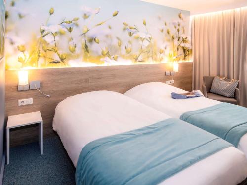 A bed or beds in a room at Mercure Trouville Sur Mer