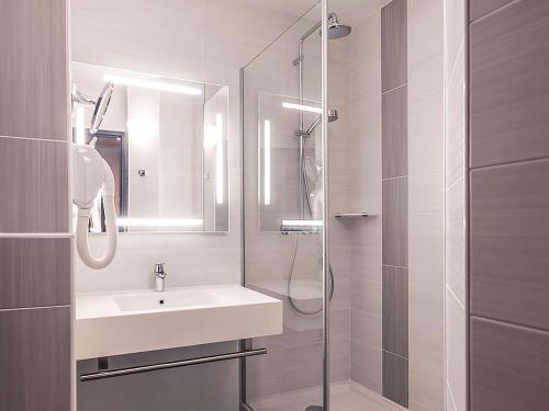 a bathroom with a sink and a shower at Mercure Trouville Sur Mer in Trouville-sur-Mer