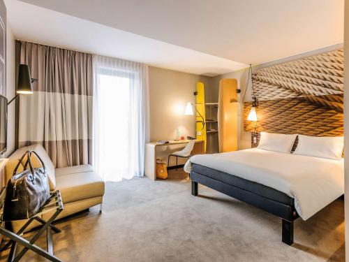 ベルリンにあるイビス ベルリン ハウプトバーンホフの大きなベッドとデスクが備わるホテルルームです。