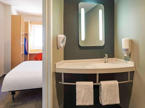 a bathroom with a sink and a bed at Ibis Culiacan in Culiacán