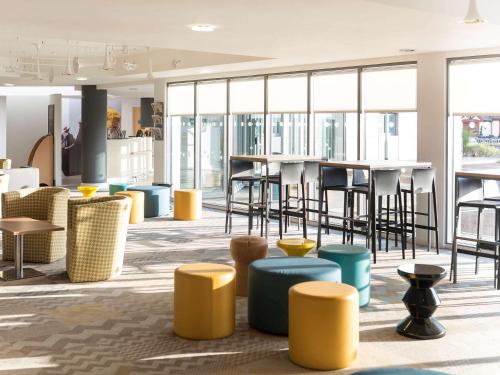 a lobby with yellow and blue stools and tables at ibis Styles Haydock in Haydock