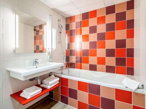 La salle de bains est pourvue d'un lavabo, d'une baignoire et d'un miroir. dans l'établissement ibis styles Albi Centre Le Theatro, à Albi