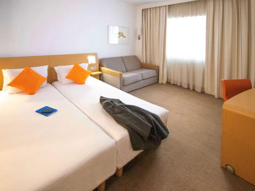 a hotel room with a bed and a chair at Novotel Tunis in Tunis