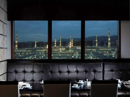a dining room with a view of a city at Pullman Zamzam Madina in Al Madinah