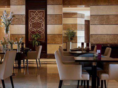 a dining room with tables and chairs and tiles at Pullman Zamzam Madina in Al Madinah