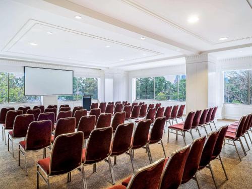 a conference room with chairs and a projection screen at Pullman Melbourne On the Park in Melbourne