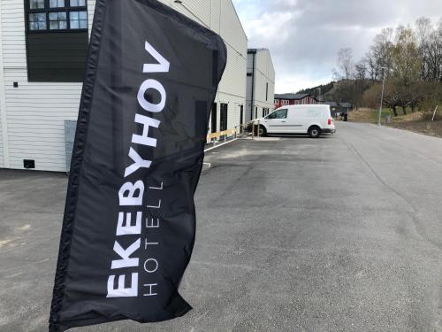 a black and white banner sitting in a parking lot at Ekebyhov Hotell in Ekerö