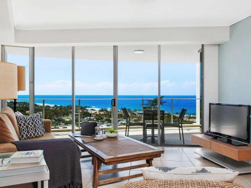 a living room with a view of the ocean at The Sebel Maroochydore in Maroochydore