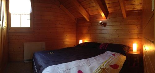 a bedroom with a bed in a wooden cabin at L'Eau-Vive in Leukerbad