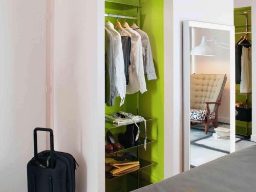 a walk in closet with a suitcase and a mirror at Mama Shelter Lyon in Lyon
