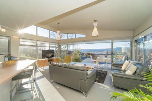 a living room with couches and a table with a view at Launceston Views Townhouses in Royal Park
