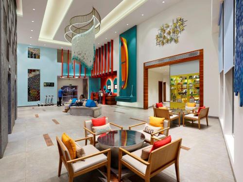 a living room filled with furniture and a large window at ibis Styles Goa Calangute - An Accor Brand in Calangute