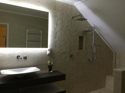 a bathroom with a sink and a shower with a mirror at Casa da azinheira in Loulé
