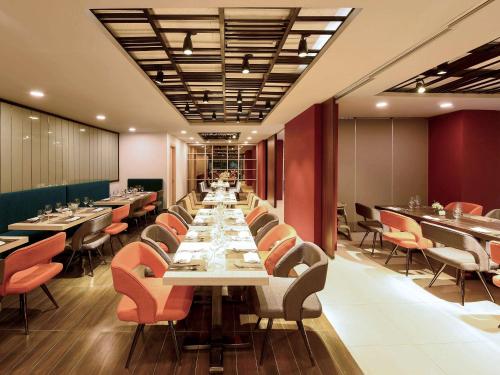 a dining room with long tables and chairs at Novotel Suites Hanoi in Hanoi