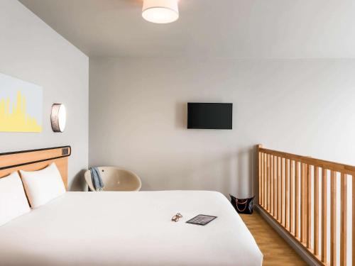 a bedroom with a bed and a tv on the wall at Aparthotel Adagio access Colombes La Défense in Colombes
