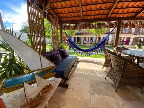 a patio with hammocks and a table and chairs at Villa Aurora in Flecheiras