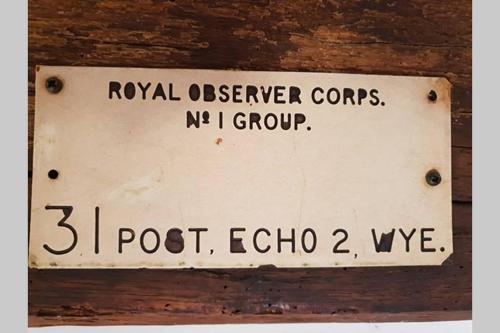 a sign on a wooden wall that reads royal observer corps and no i group at Plumpton Barn in Ashford