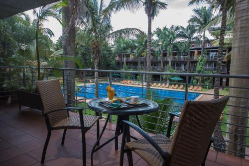 a balcony with a table and chairs and a pool at Kabira Country Club in Kampala