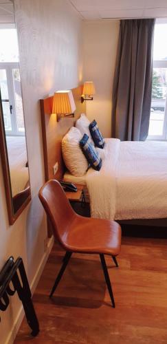 a bedroom with a bed and a chair at Hotel Asiris in Bruges