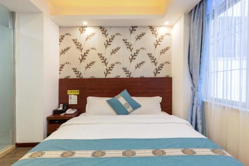 Un dormitorio con una cama grande y una ventana en YIMI Hotel Guangzhou International Convention and Exhibition Center Guangzhou Tower Branch en Cantón