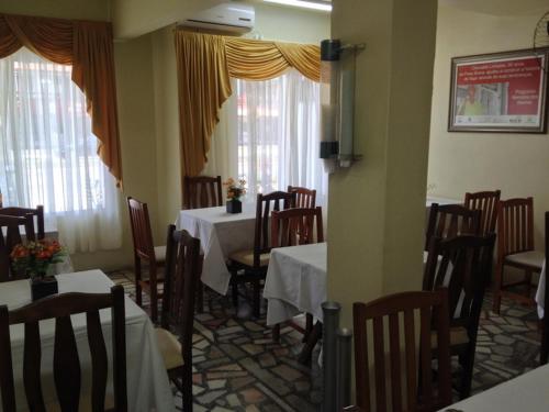 伊塔雅伊的住宿－Hotel Linhares，用餐室设有桌椅和窗户。