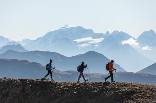 a group of three people walking on top of a mountain at Hotel Amerikan in Livigno
