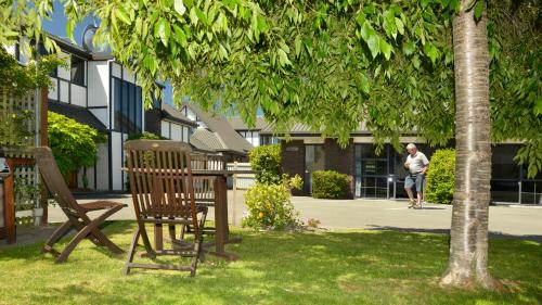 a man standing in a park under a tree at Aston Court Motel in Blenheim