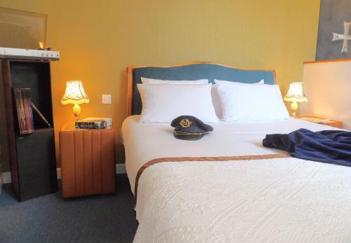 a bedroom with a bed with a hat on it at Detective Hotel in Étretat