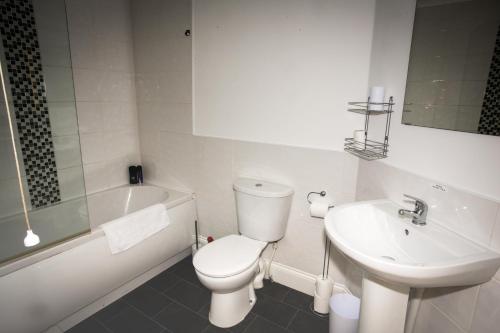 蒂斯河畔斯托克頓的住宿－Norton Serviced Apartments，白色的浴室设有卫生间和水槽。