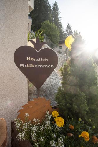 a sign for a hirsch willimann sign with flowers at Hotel Alta Vista in Neukirchen am Großvenediger
