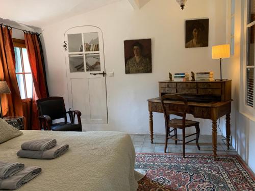 a bedroom with a desk and a bed and a table at Mymoustiers in Moustiers-Sainte-Marie