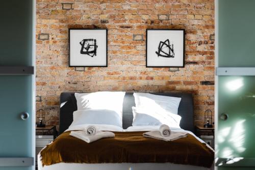 een slaapkamer met een bakstenen muur en een bed bij Luxurious Urban Living - Premium Downtown Apartments next to HBF in Berlijn