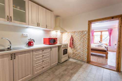 a kitchen with white cabinets and a red microwave at Penzion Hluk in Hluk